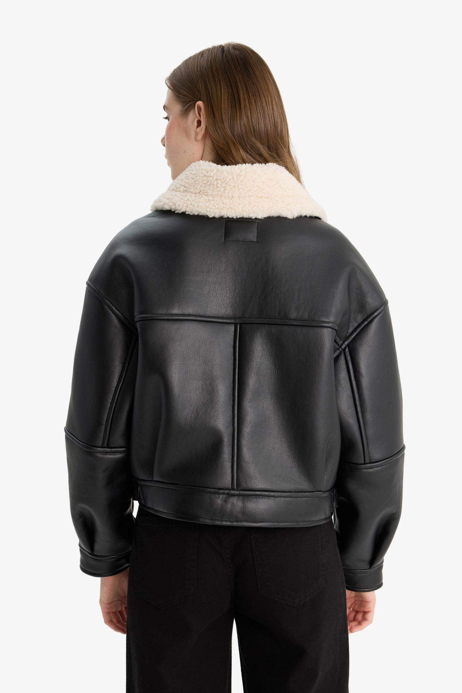 Oversize, loose-fitting faux leather jacket with faux fur lining and zipper closure.