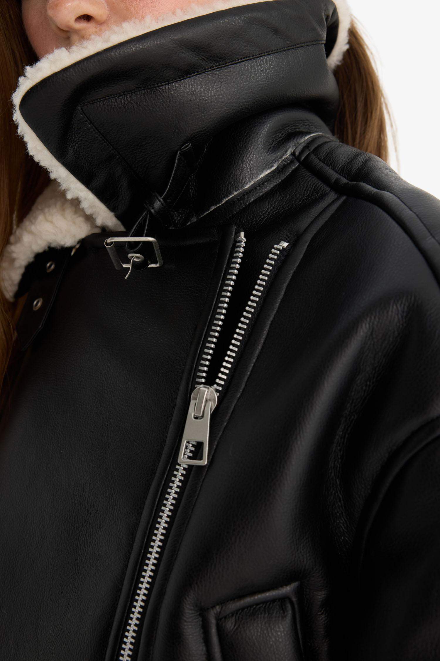 Oversize, loose-fitting faux leather jacket with faux fur lining and zipper closure.