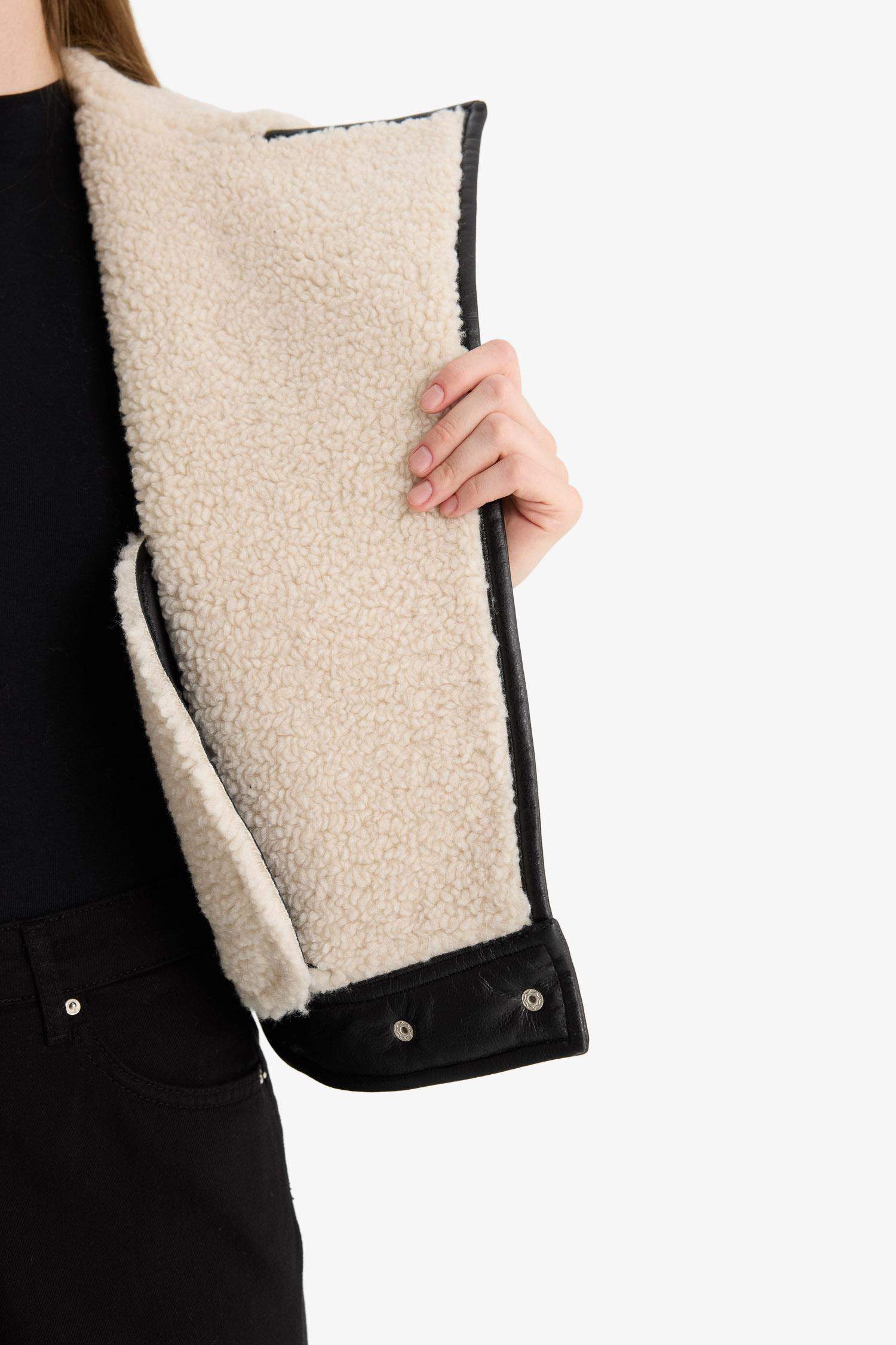 Oversize, loose-fitting faux leather jacket with faux fur lining and zipper closure.