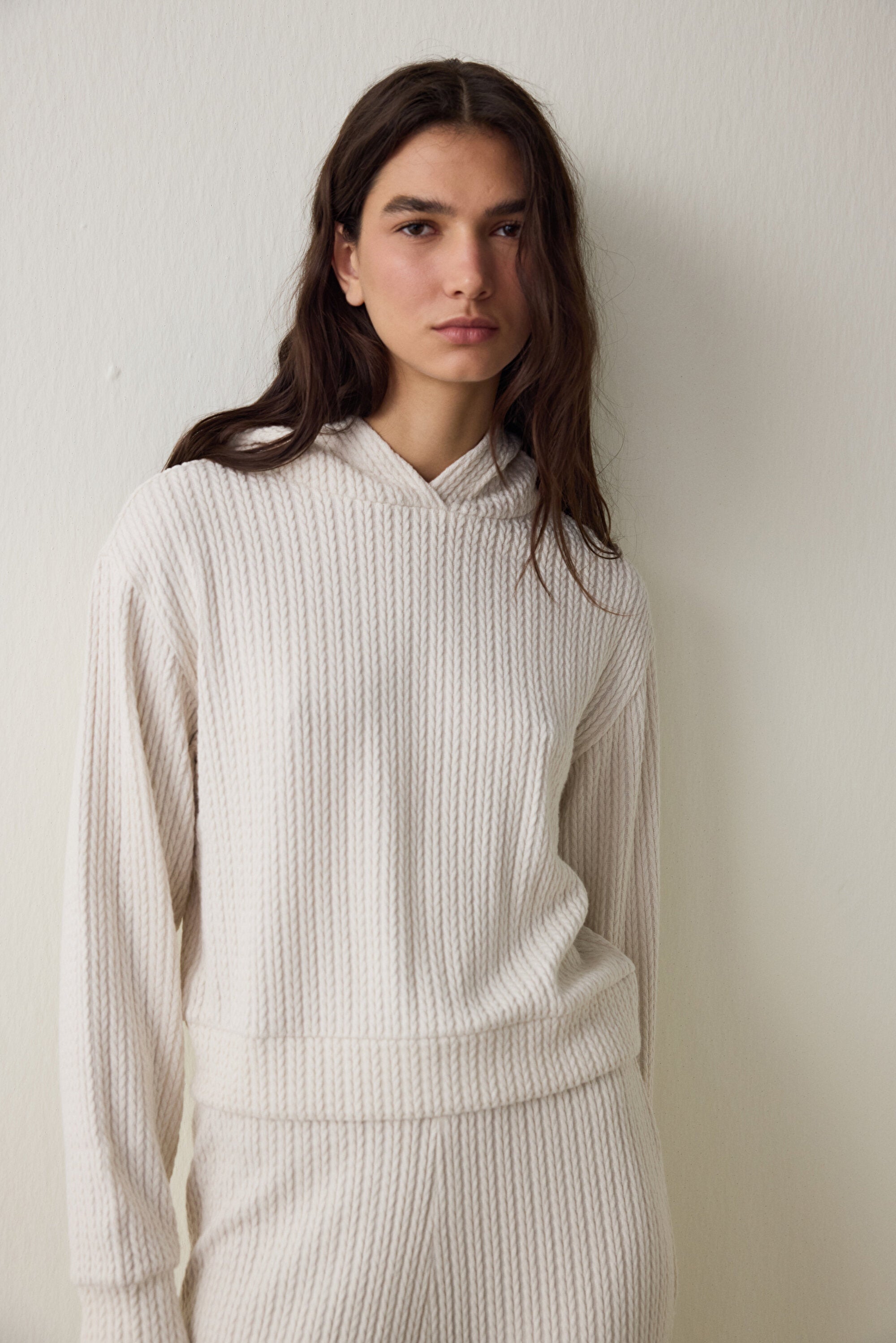 Off-white hooded sweatshirt with knitted detail.