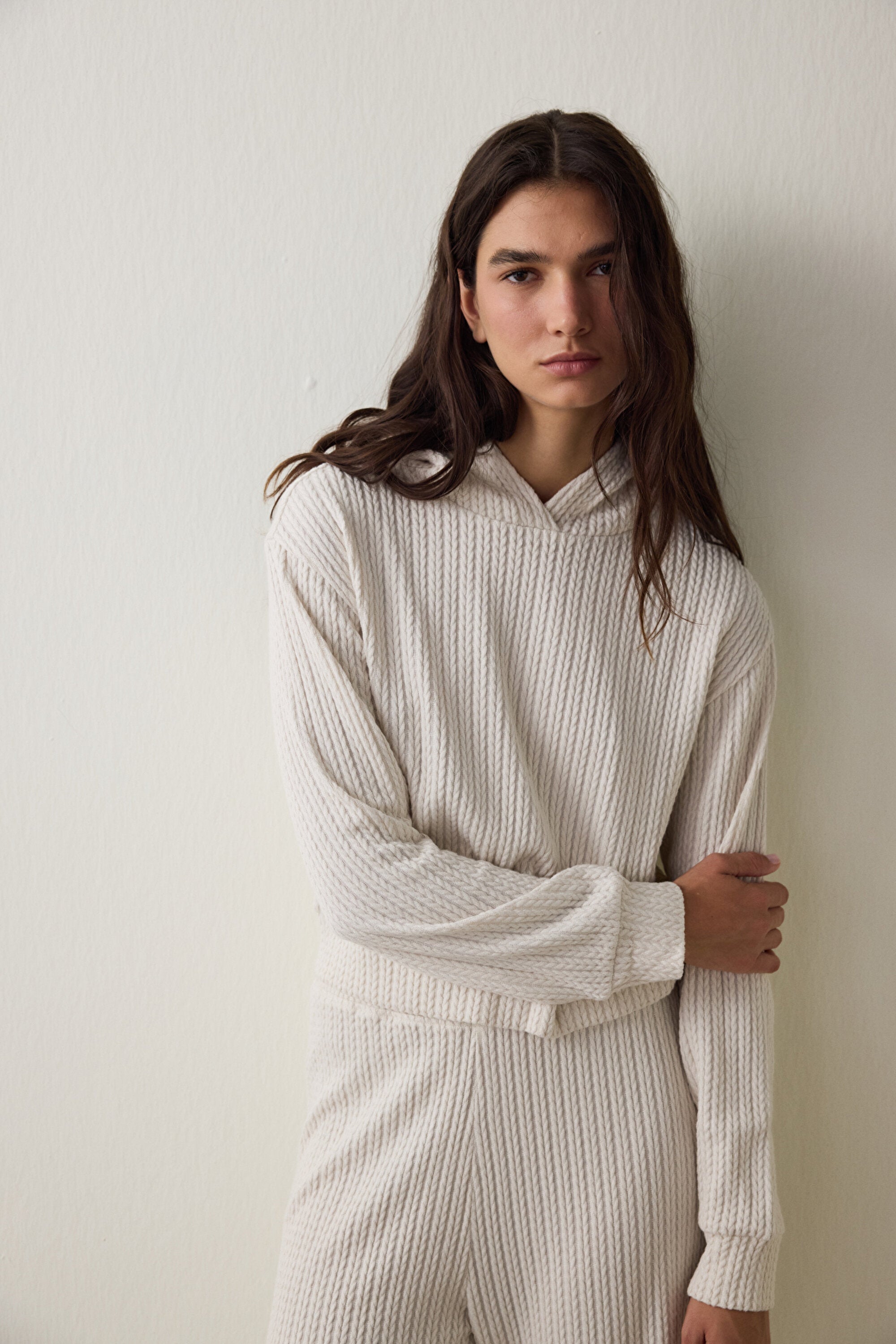 Off-white hooded sweatshirt with knitted detail.