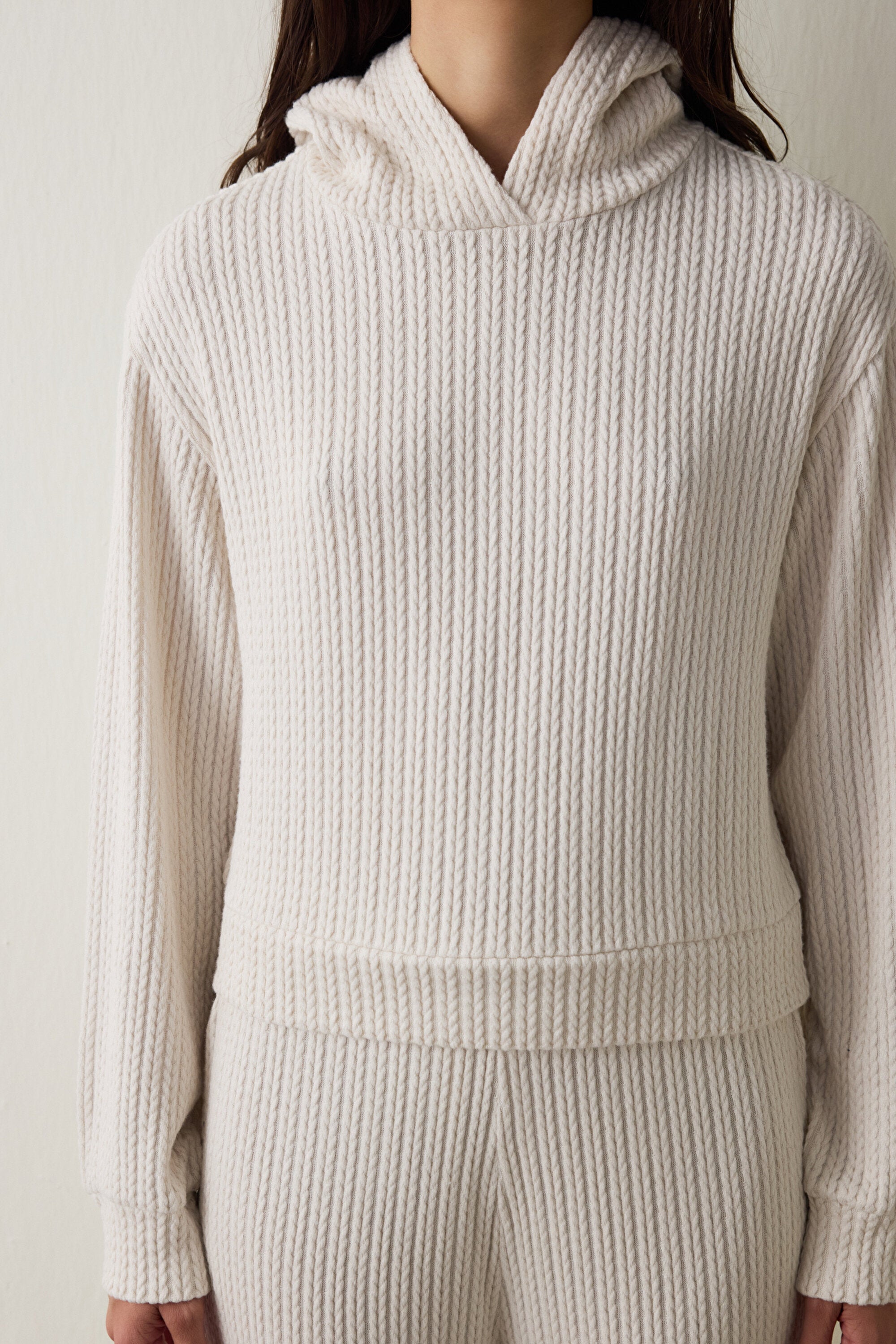 Off-white hooded sweatshirt with knitted detail.