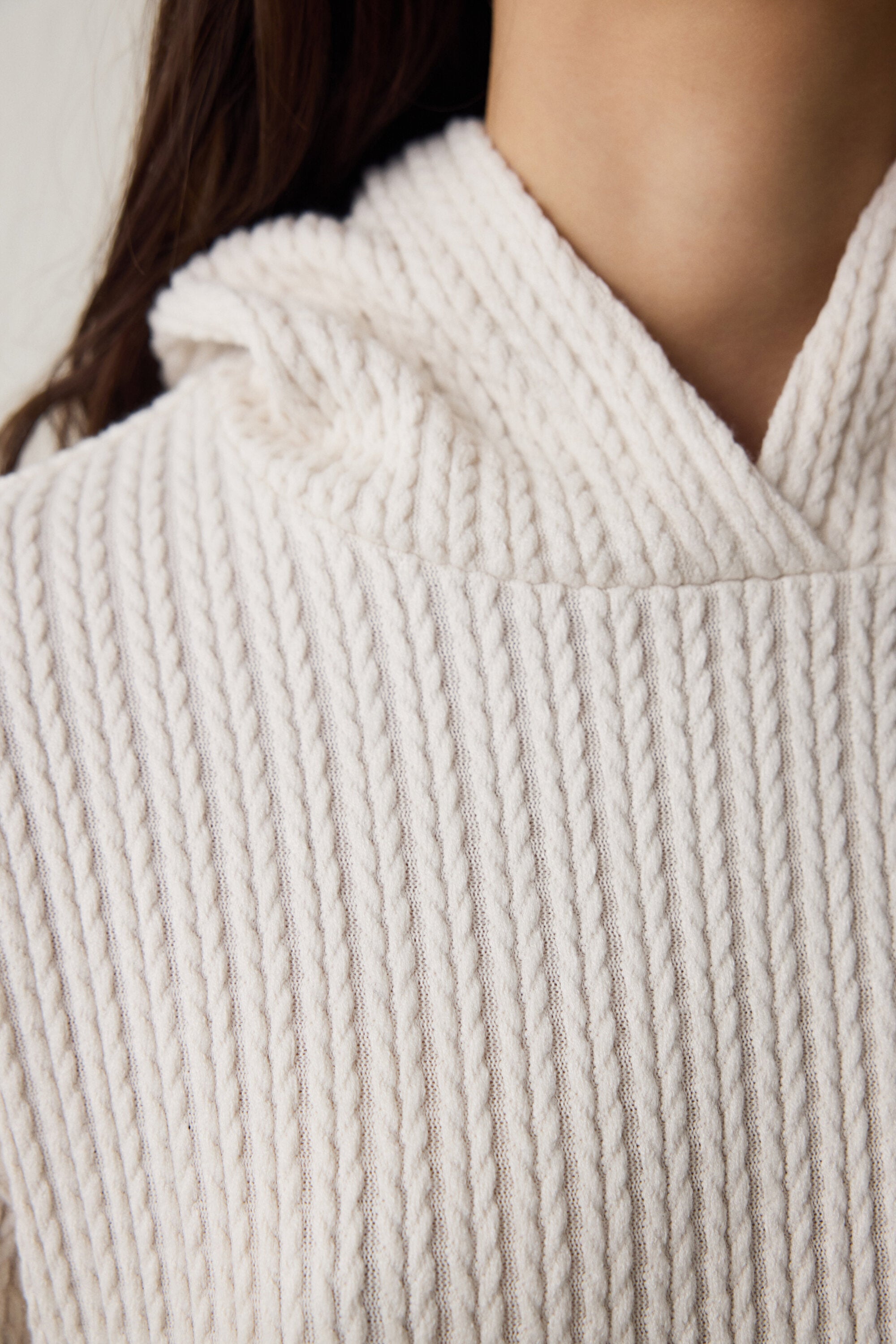 Off-white hooded sweatshirt with knitted detail.